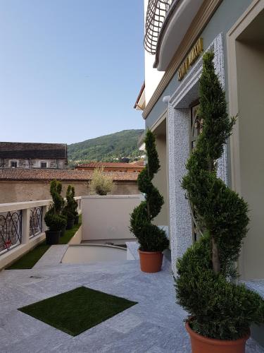 a courtyard with potted plants in front of a building at Hotel Al Campanile - Luxury Suites & Apartments in Baveno