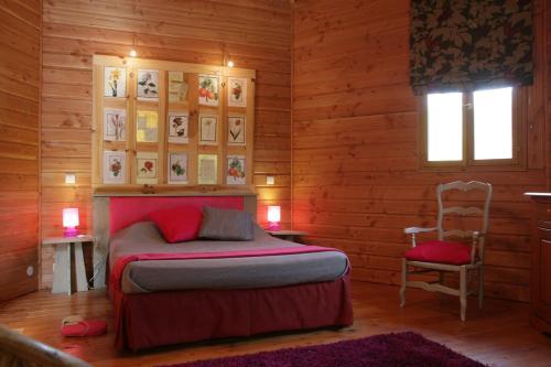 1 dormitorio con 1 cama y 1 silla en le refuge des pots rouges, en Cros
