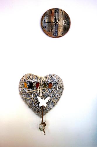 a heart made out of recycled glass and a clock at Hotel Lux in Cesenatico