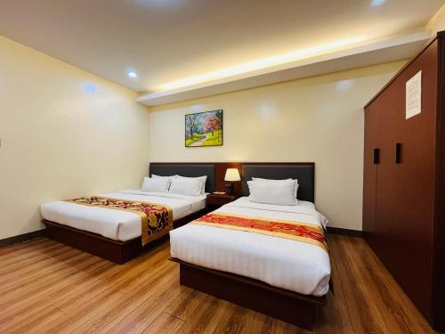 a hotel room with two beds in a room at Starway Hotel and Restaurant in Baguio