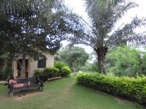 a person sitting on a bench in a yard at Wli Water Heights Hotel in Wli Afegame