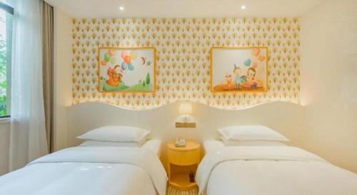 a bedroom with three beds and a yellow table at Deefly Yinrun Town Hotel in Deqing