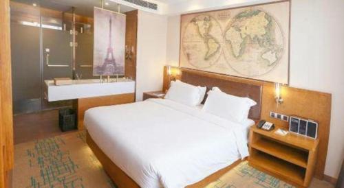 a bedroom with a large white bed and a sink at James Joyce Coffetel Changchun People's Square in Changchun