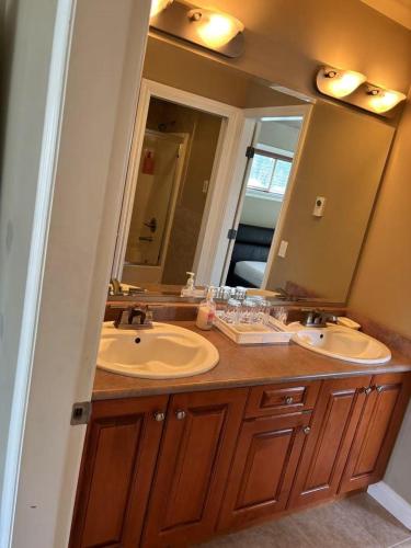 a bathroom with two sinks and a large mirror at Rosehouse 2Bedrooms sleep 4 2nd floor private bathroom in Coquitlam