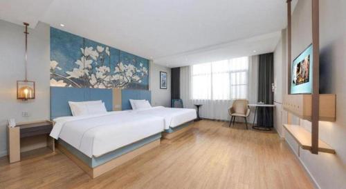 a bedroom with a large white bed in a room at Magnotel Hotel Xiamen North Station Binhai in Xiamen