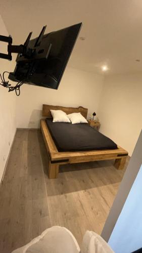 a bedroom with a bed with a tv on the wall at Hébergement curgy in Curgy