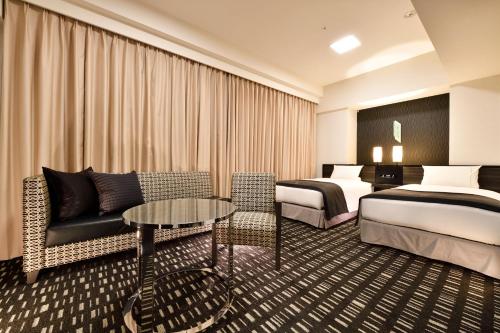 a hotel room with two beds and a couch at The Royal Park Hotel Tokyo Haneda Airport Terminal 3 in Tokyo