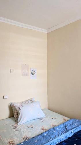 a bedroom with a bed with a blue comforter at Surabaya Homey Dharmahusada Syariah in Surabaya
