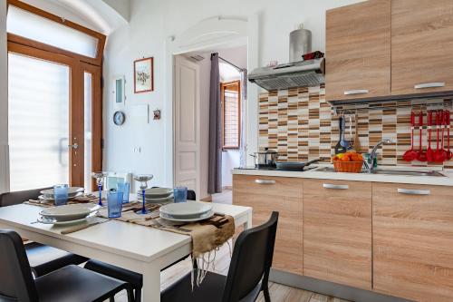 a kitchen with a table and chairs in a kitchen at Giosue' Apartment Near Bari - Happy Rentals in Adelfia