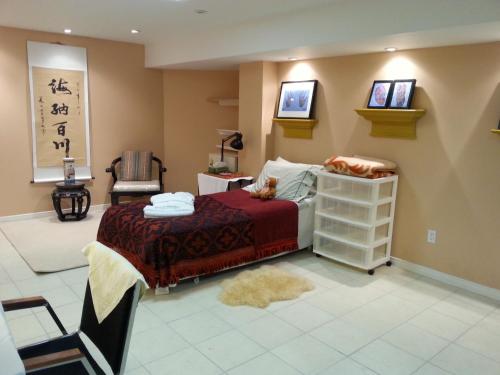 a bedroom with a bed and a chair in a room at Maria's Homestay in Thornhill