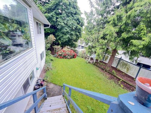 a yard with a fence and a house at Cozy Nook in Fraser Valley Getaway With Breakfast in Abbotsford