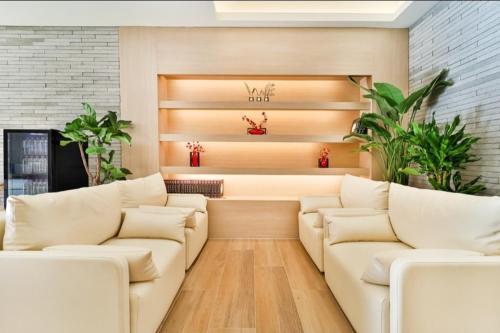 a living room with white couches and plants at The Hound Hotel Changwon Terminal in Changwon