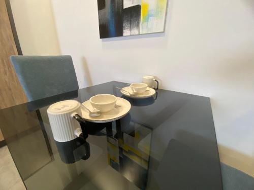 a black table with two cups and a chair at Imperio Residence Melaka by Jeffery Lam Home Management in Melaka