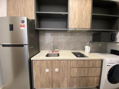 a small kitchen with a sink and a refrigerator at Imperio Residence Melaka by Jeffery Lam Home Management in Melaka