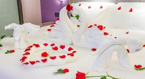 a white bed with red hearts on it at Lavande Hotel Huizhou Shiwan in Huizhou
