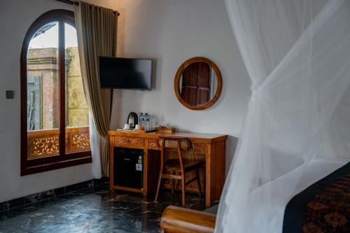 a bedroom with a desk and a bed and a mirror at Grand Campuhan in Tegalalang
