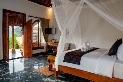 a bedroom with a bed with a canopy at Grand Campuhan in Tegalalang
