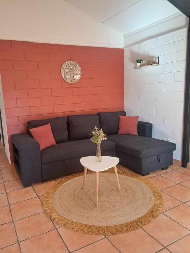 a living room with a couch and a table at La kaz de l'arbre voyageur in LʼEntre-Deux