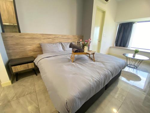 a bedroom with a large bed with a wooden headboard at Imperio Residence Melaka by Jeffery Lam Home Management in Melaka