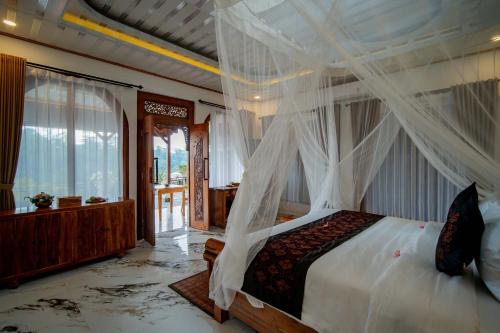 a bedroom with a bed with a canopy at Grand Campuhan in Tegalalang