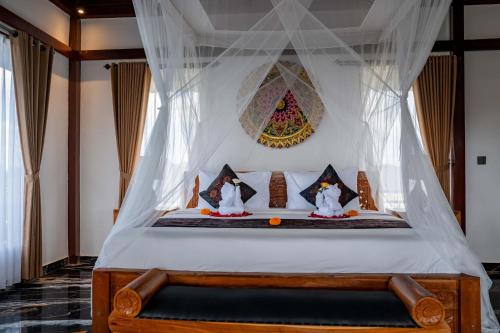 a bedroom with a bed with a canopy at Grand Campuhan in Tegalalang