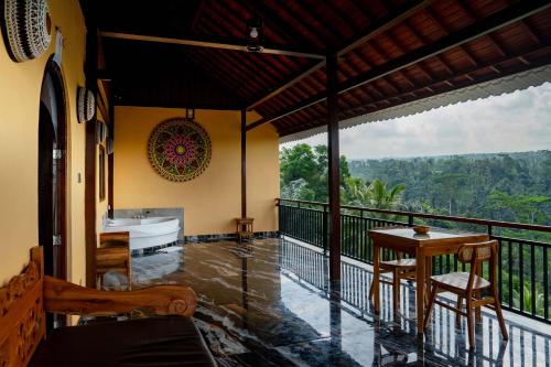 a room with a balcony with a tub and a table at Grand Campuhan in Tegalalang