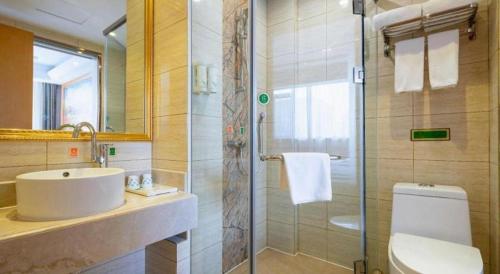 a bathroom with a sink and a shower and a toilet at Vienna Hotel Tianjin 5th Avenue Youyi Road Cultural Center Metro Station in Tianjin