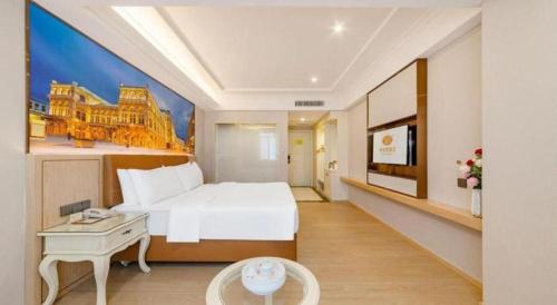 a hotel room with a bed and a table at Vienna Hotel Guangdong Shantou South Bus Station in Shantou