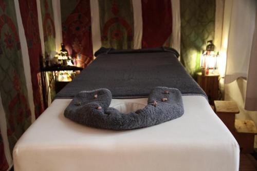 a pair of slippers sitting on top of a bed at Dar El Qadi in Marrakech