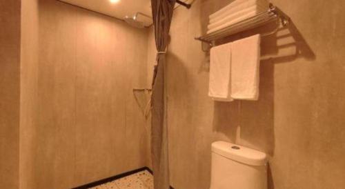 a bathroom with a white toilet and towels at Shell Hotel Beijing Shunyi District Shunyi Metro Station in Beijing