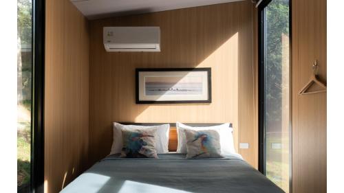 a bedroom with a bed with a picture on the wall at Loburn Retreat 2 by Tiny Away in Loburn
