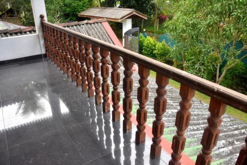 a wooden railing on a balcony with a view of a house at Grand Breeze Hotel 