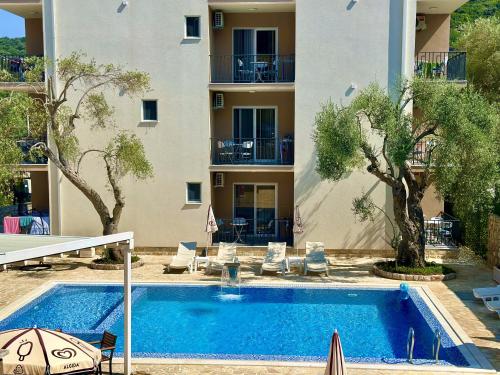 a swimming pool in front of a building at Akhdar Apartments in Utjeha