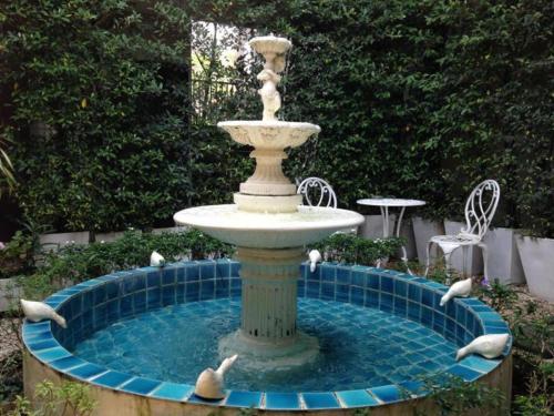 a fountain with four birds swimming around it at C2 Residence Hotel in Lampang