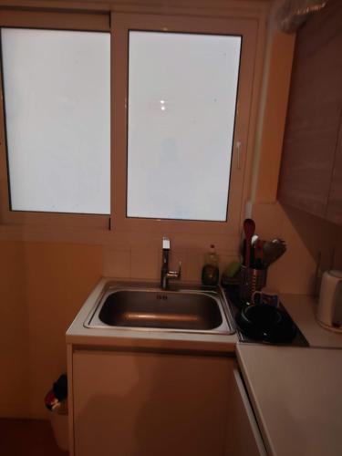 two windows above a sink in a kitchen at Kolonaki Budget Rooms in Athens