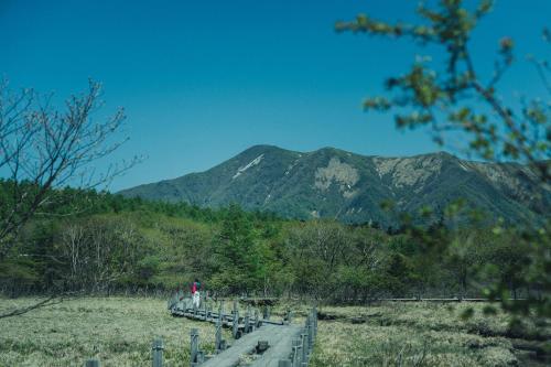 a mountain in the distance with a bridge and trees at SANU 2nd Home 那須2nd in Nasu