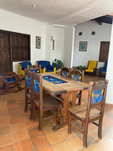 a dining room with a wooden table and chairs at Hotel Campestre Villa Lucila in San Gil