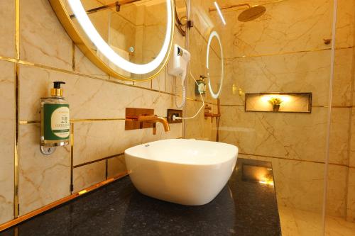 a bathroom with a white sink and a mirror at Chitralekha Boutique Resort in Rājpur