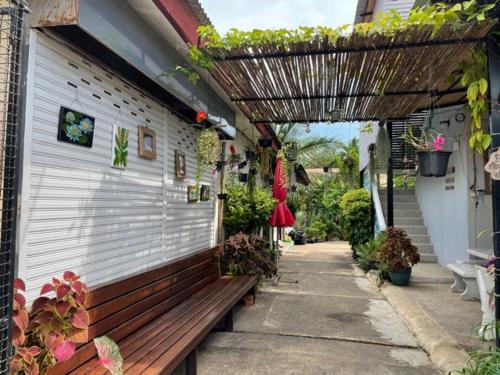 a wooden bench sitting outside of a building at Anattaya Holiday Home in Ko Yao Noi
