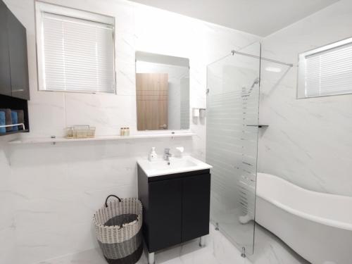 a white bathroom with a sink and a shower at Pool Story 6 in Jeju