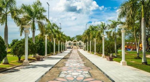 a walkway lined with palm trees in a park at Traders Inn Brunei in Bandar Seri Begawan
