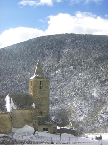 a building with snow on the ground next to a mountain at Hotelet de Betlan in Betlán