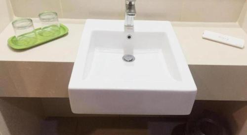 a white sink with a faucet on a counter at Evora Hotel in Surabaya