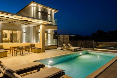 a villa with a swimming pool at night at KALIMERA Luxurious Villas in Lixouri