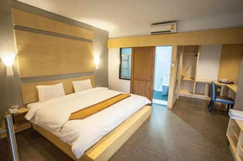 a bedroom with a large bed and a bathroom at NH Elegant Hotel in Sakon Nakhon