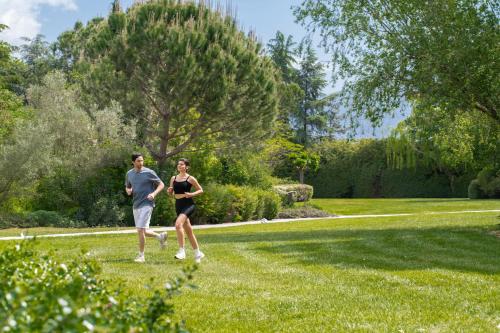 a man and woman running in a park at Hyatt Regency Thessaloniki in Thessaloniki