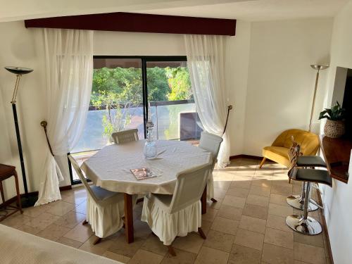 a dining room with a table and a large window at Poerava Tahiti in Papeete