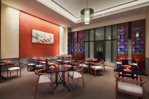 a restaurant with tables and chairs in a room at Derayco Hotel Foshan in Shunde