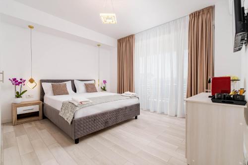 a bedroom with a bed and a television in it at Hotel Boutique Tunari in Tunari