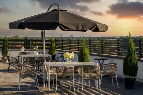 a patio with tables and chairs under an umbrella at Hotel Boutique Tunari in Tunari